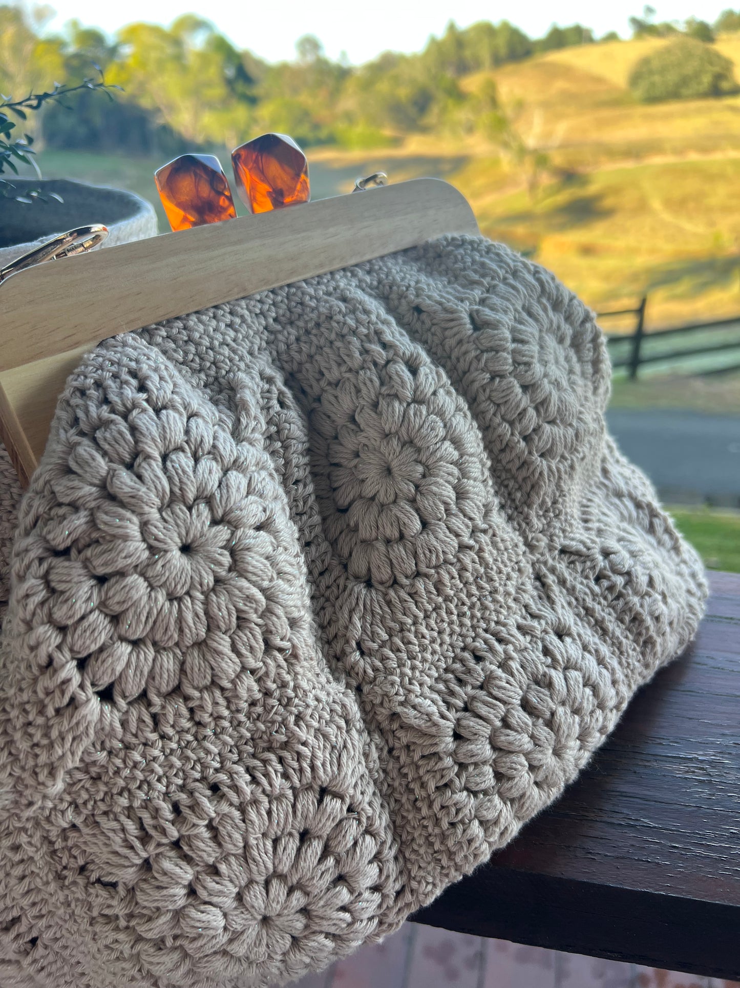 Hand- Crocheted Clutch Bag with Wooden Frame and Amber style kiss lock.